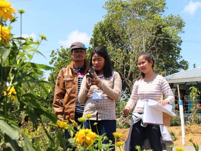 Jinny Pearl April Noble of NAMAMAYUK (middle) leads the measurement of the respondent’s garden, together with Jemma Rey Pongautan of NAMAMAYUK (right).