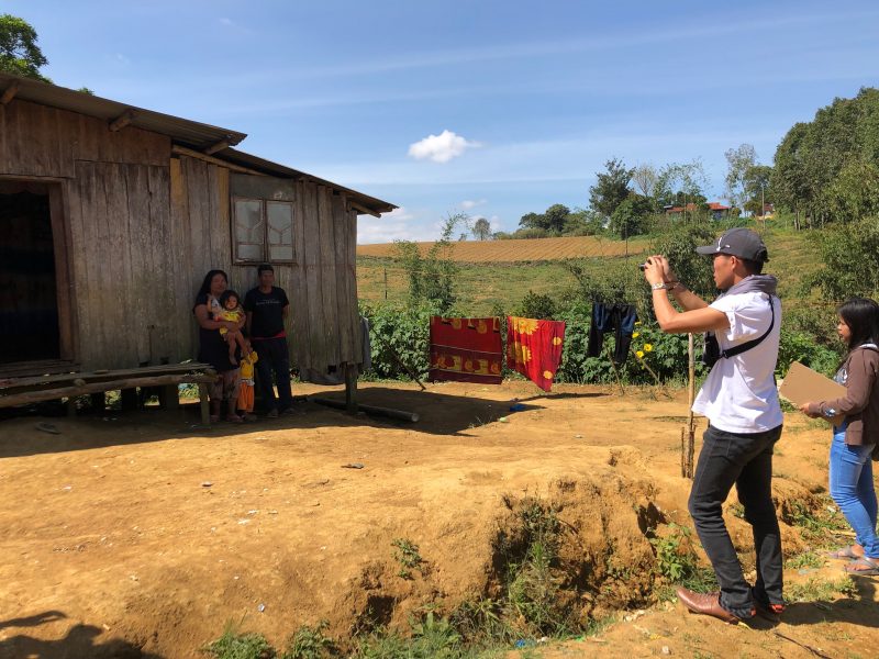 Melvin Pongautan (white shirt) of NAMAMAYUK takes a photo of the respondent’s family in front of their house.